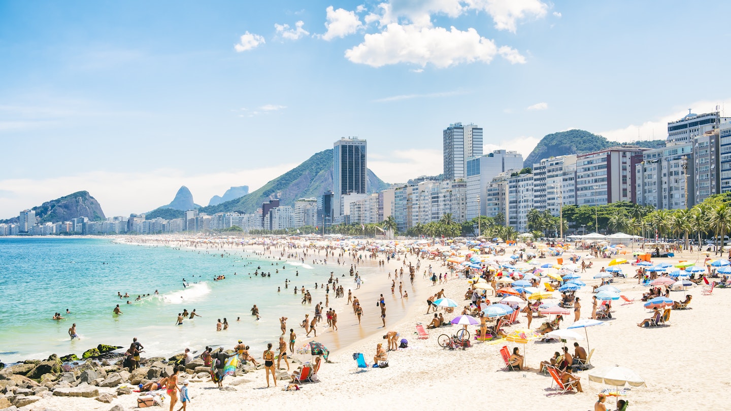 The crowded summer shoreline of Copacabana Beach in Rio de Janeiro.