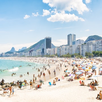 The crowded summer shoreline of Copacabana Beach in Rio de Janeiro.