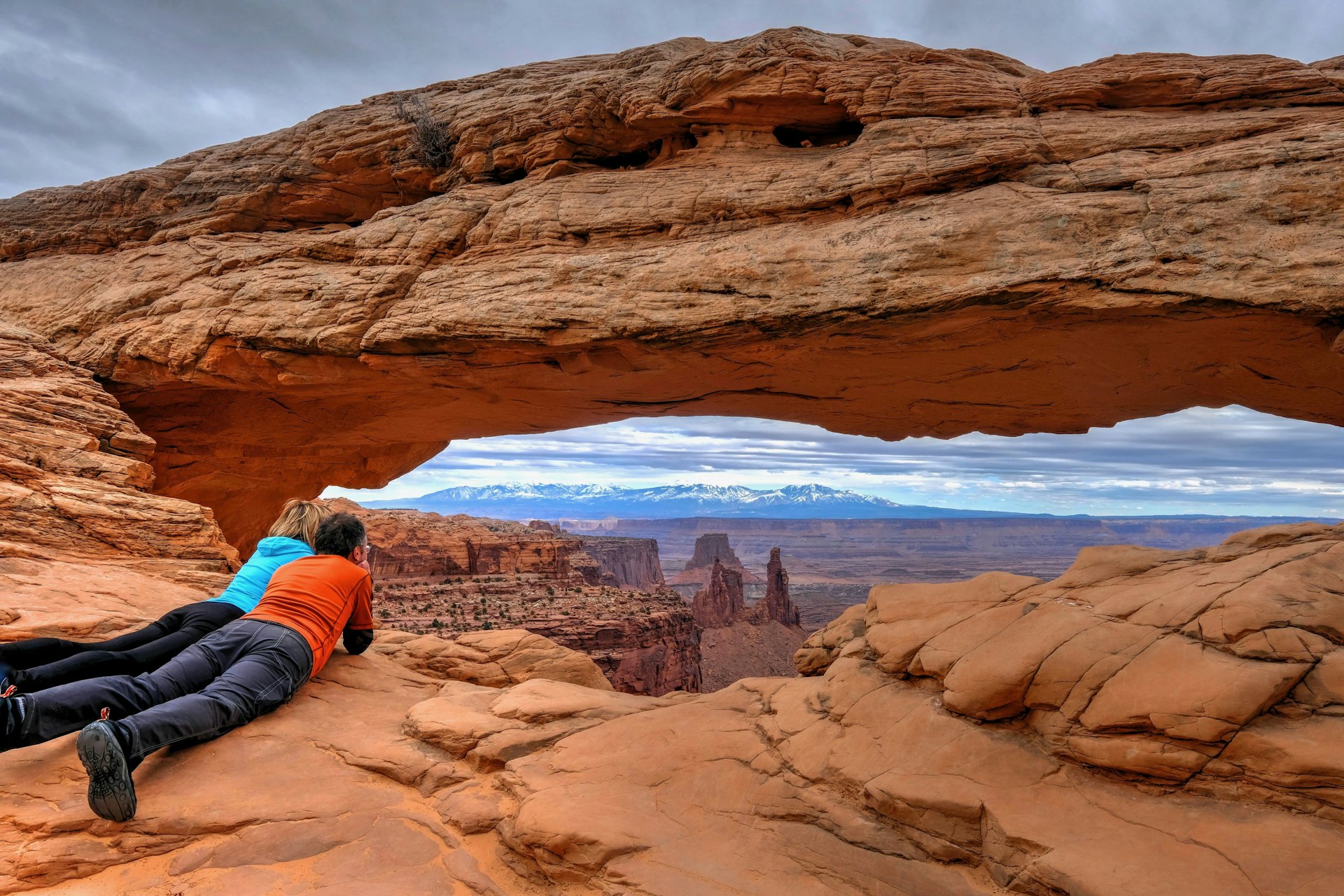 Walkers looking at a rock arch in Utah