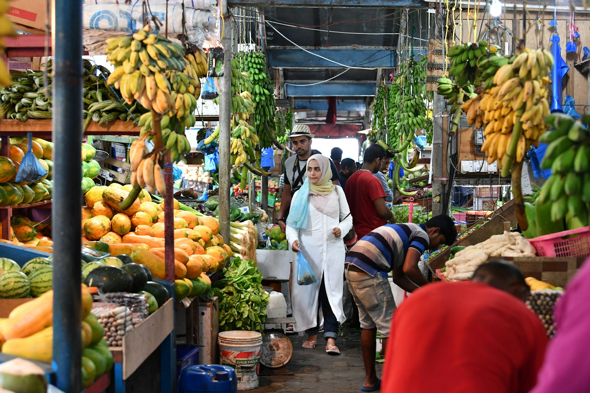 People buying fruit and vegetables at an island market in Male. 