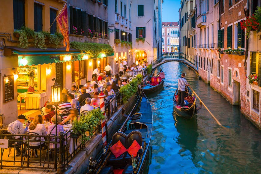 View of canal in Venice Italy at night with gondolas 