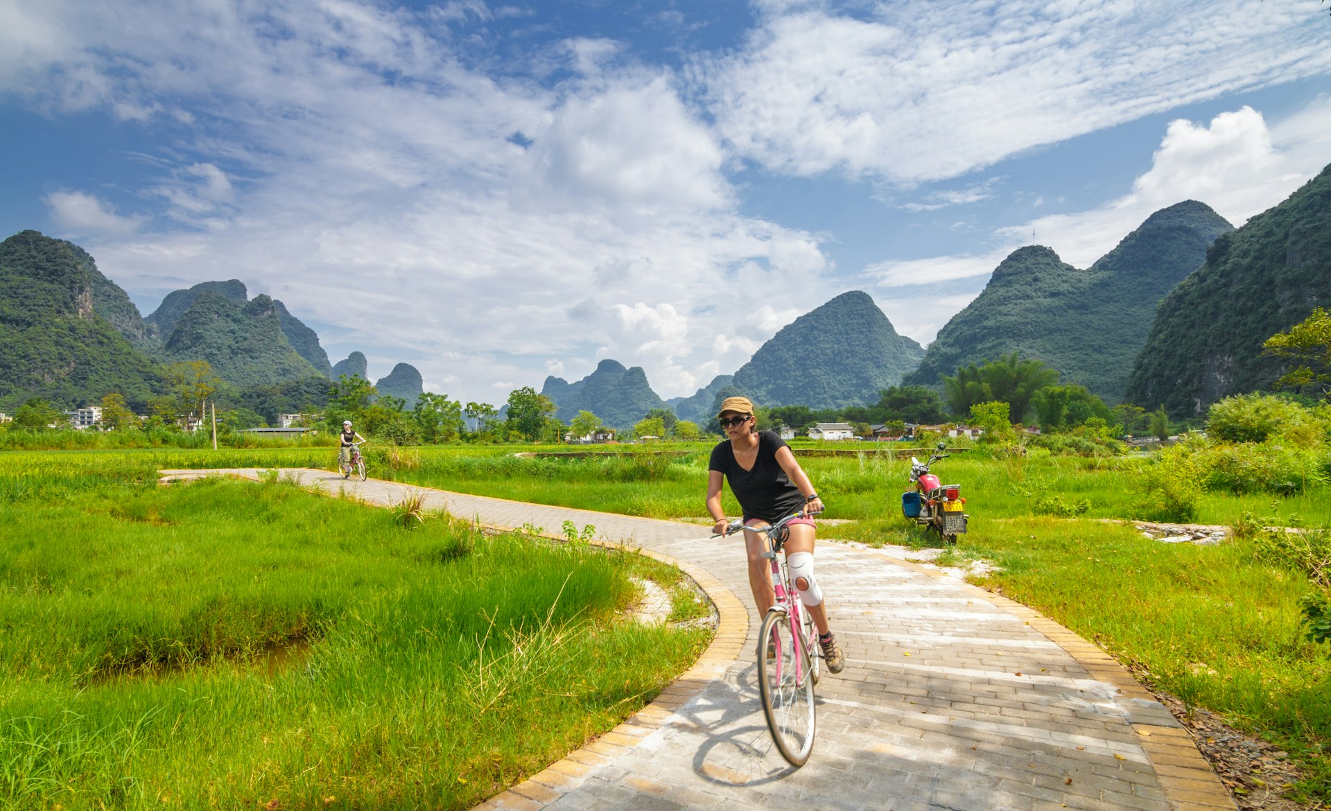 Cyclist passing hills in Yangshuo, Guilin
