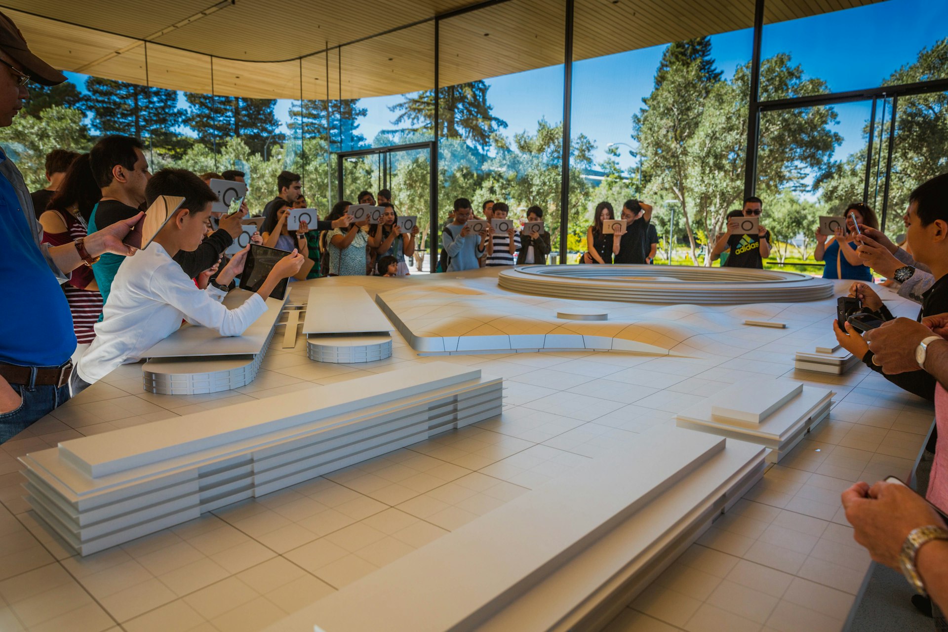 Visitors admire a model of Apple's futuristic HQ, San Jose