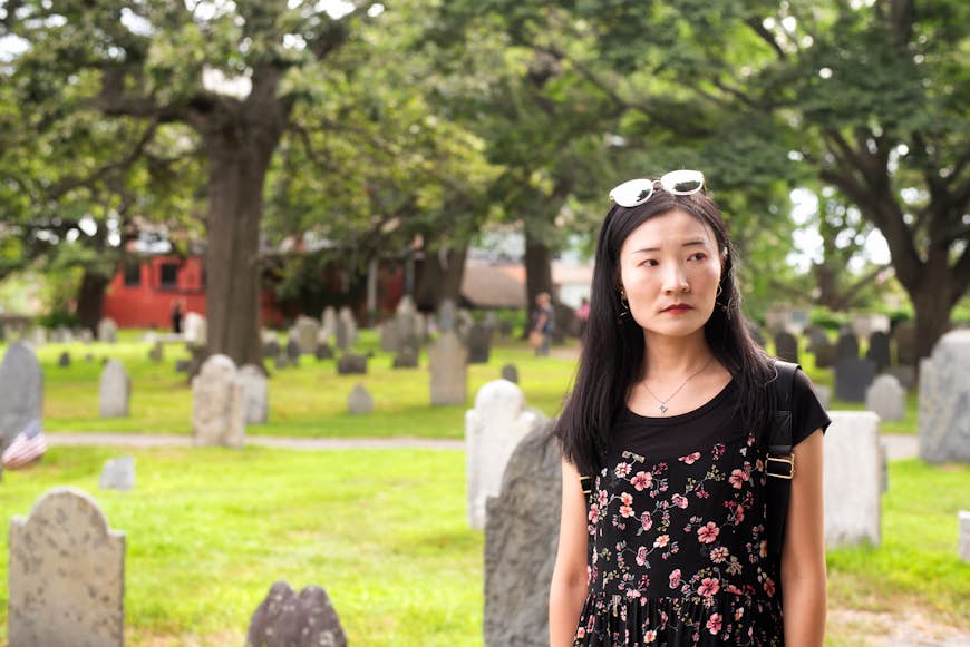En asiatisk kvinna som ser mörk ut på Burying Point-kyrkogården i Salem 