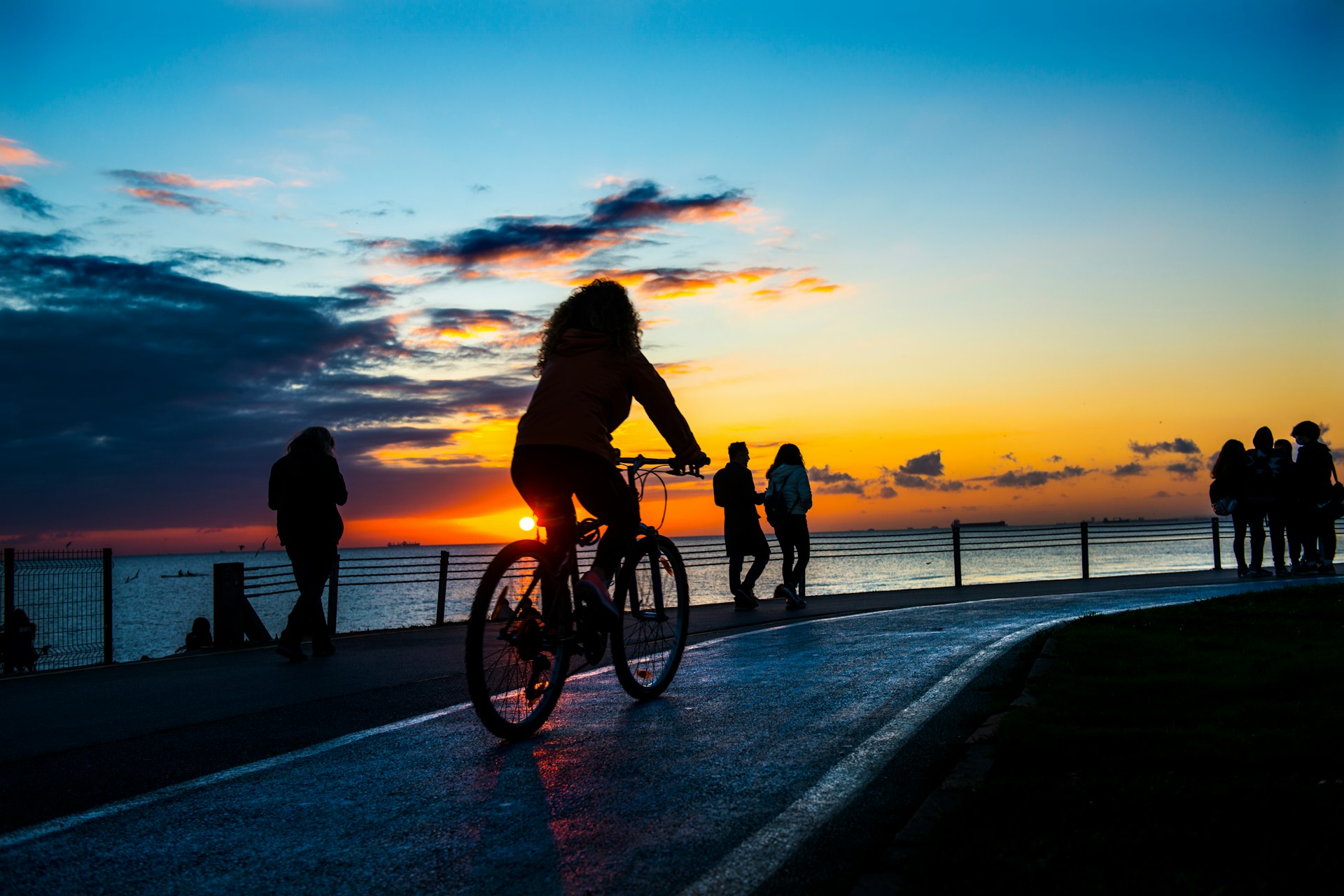 People ride bicycles at sunset in Caddebostan, Istanbul, Turkey