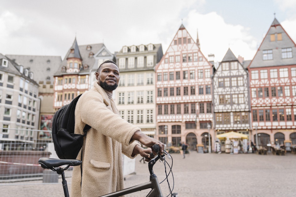 Germany, Frankfurt, Stylish man with a bicycle in old town.