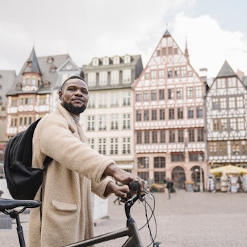 Germany, Frankfurt, Stylish man with a bicycle in old town.
