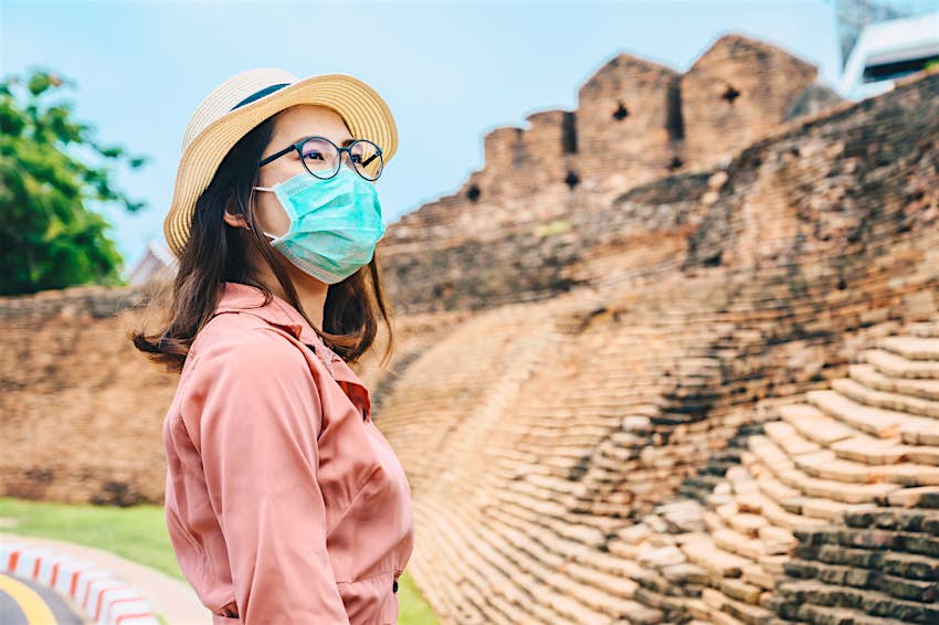 Portrait d'une jeune touriste asiatique portant un masque pour empêcher la propagation du virus lors d'un voyage dans la province de Chiang Mai en Thaïlande pendant la pandémie de Covid-19.