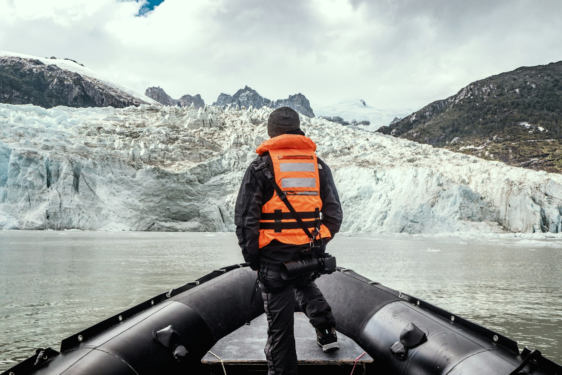 Man standing on a boat looking at the glacier