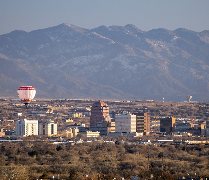 A hot air balloon floats over the skyscrapers of downtown Albuquerque, New Mexico.