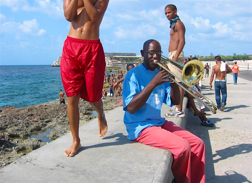 Cuban musician playing trombone on the Malecon seafront.