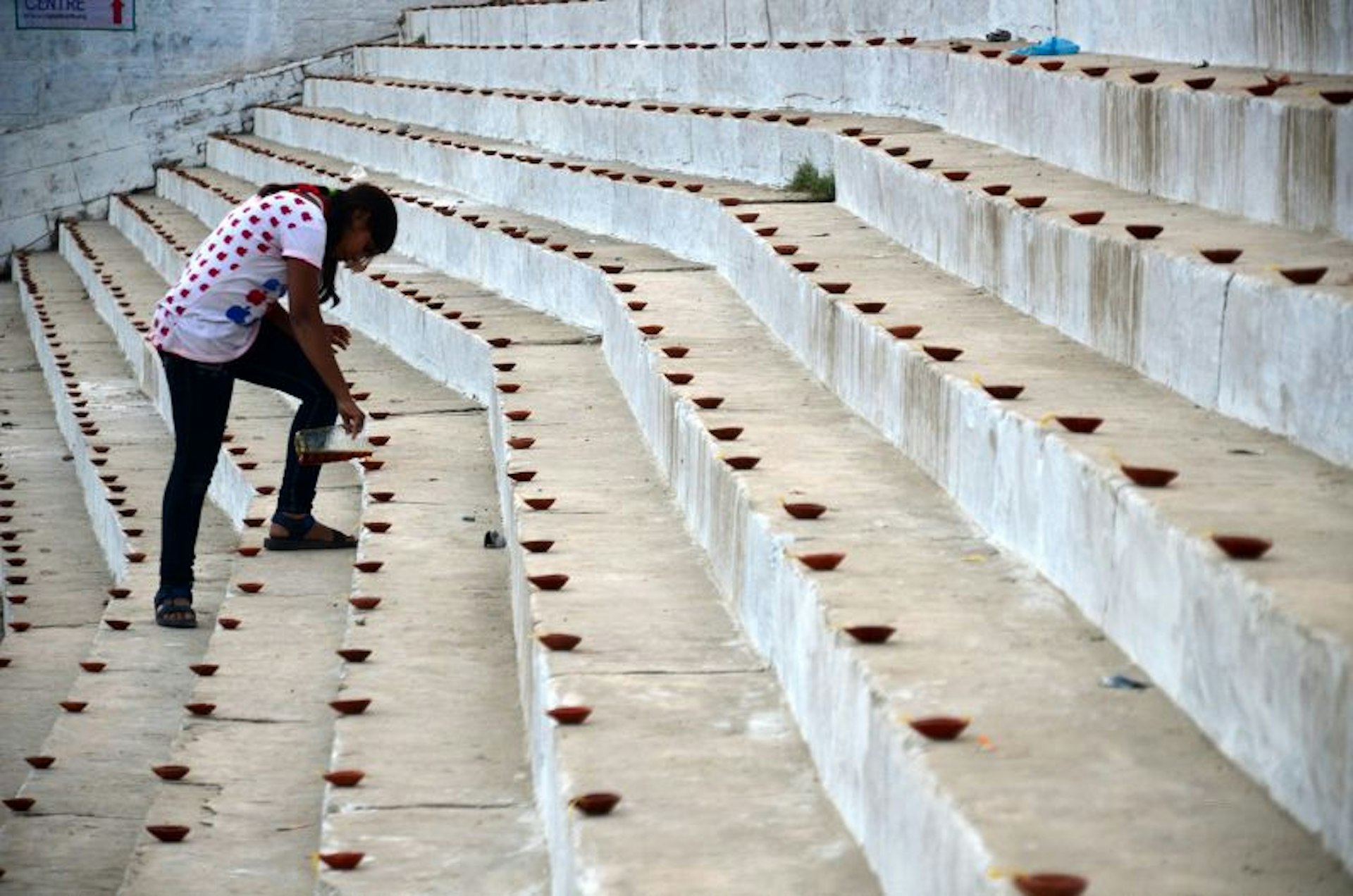 Woman preparing candles on steps at Dev Deepavali ('the Diwali of the Gods' or 'Festival of Lights of the Gods') is the festival of Kartik Poornima.