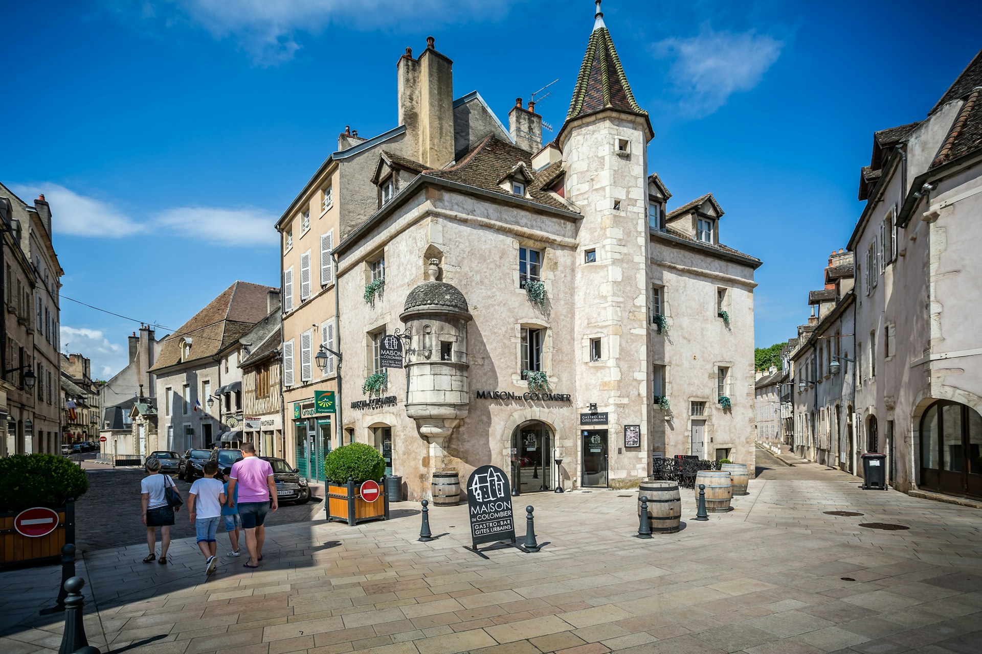 A large grey medieval building dominates the quiet streets of Beaune with pretty shops nearby