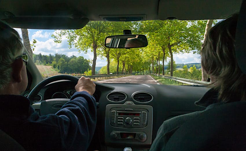 Une vue sur la campagne bourguignonne à travers le pare-brise d'un couple en road trip