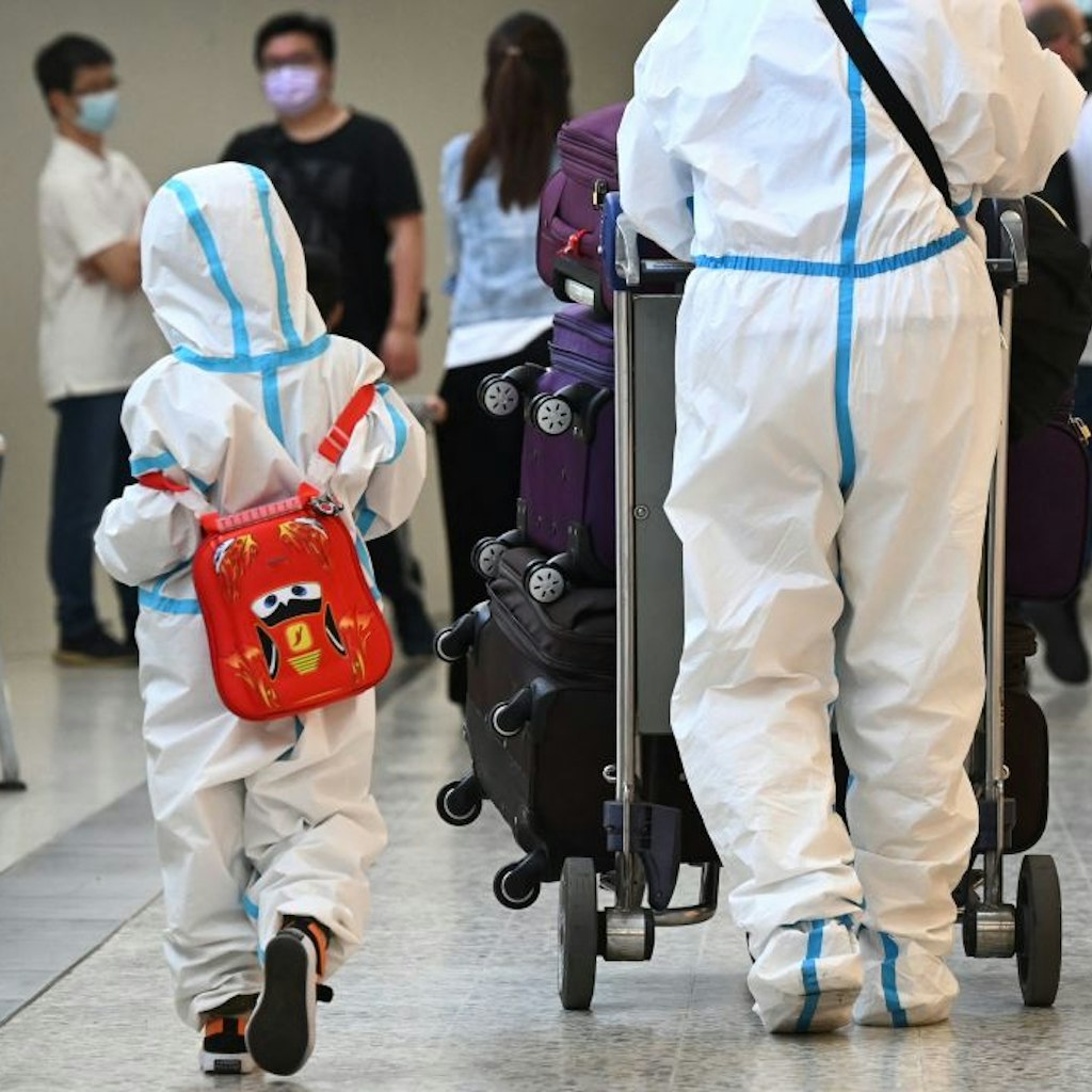 TOPSHOT - International travellers wearing personal protective equipment (PPE) arrive at Melbourne's Tullamarine Airport on November 29, 2021 as Australia records it's first cases of the Omicron variant of Covid-19. (Photo by William WEST / AFP) (Photo by WILLIAM WEST/AFP via Getty Images)