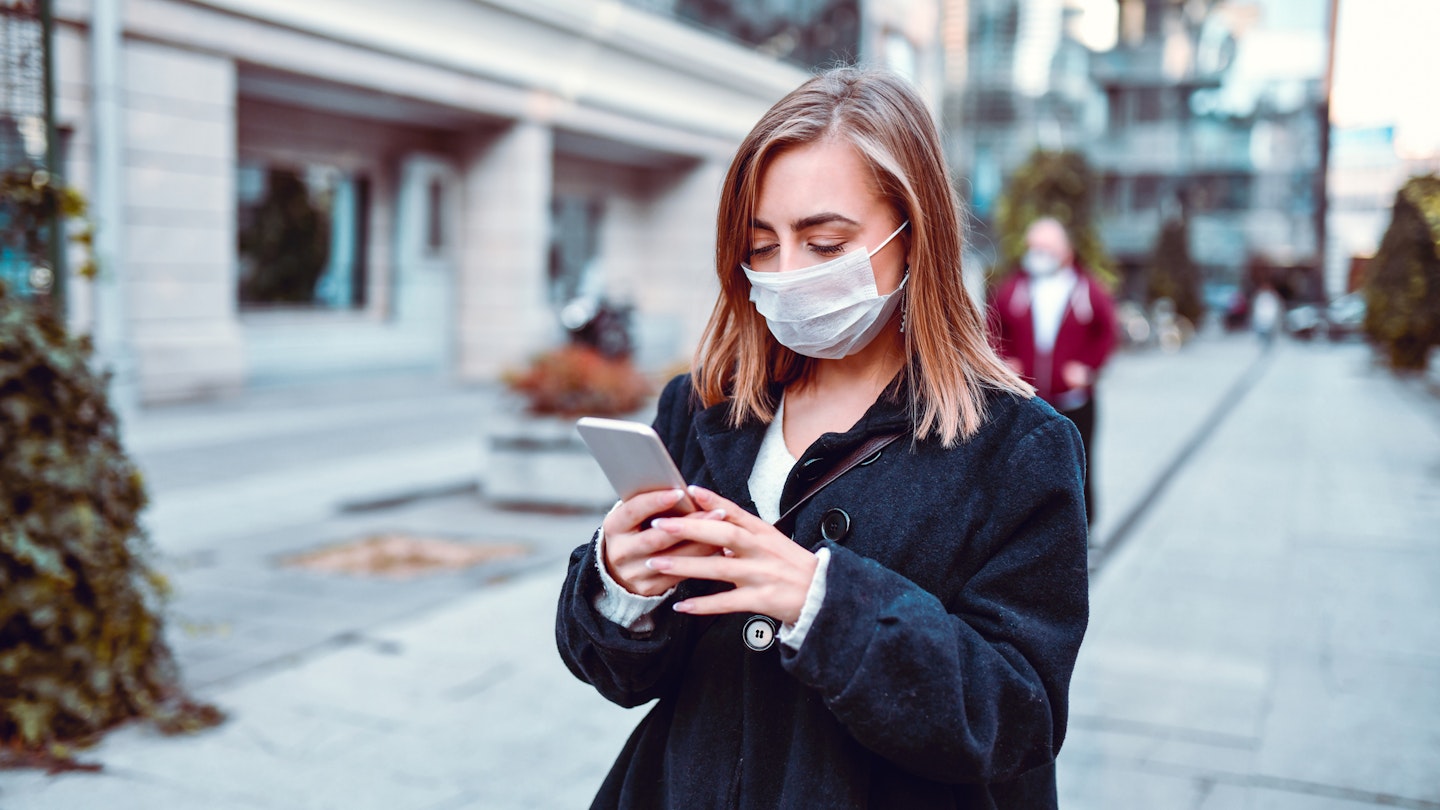 Female Finding Her Way On GPS While Wearing Anti Air Pollution Mask