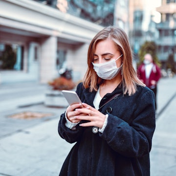 Female Finding Her Way On GPS While Wearing Anti Air Pollution Mask