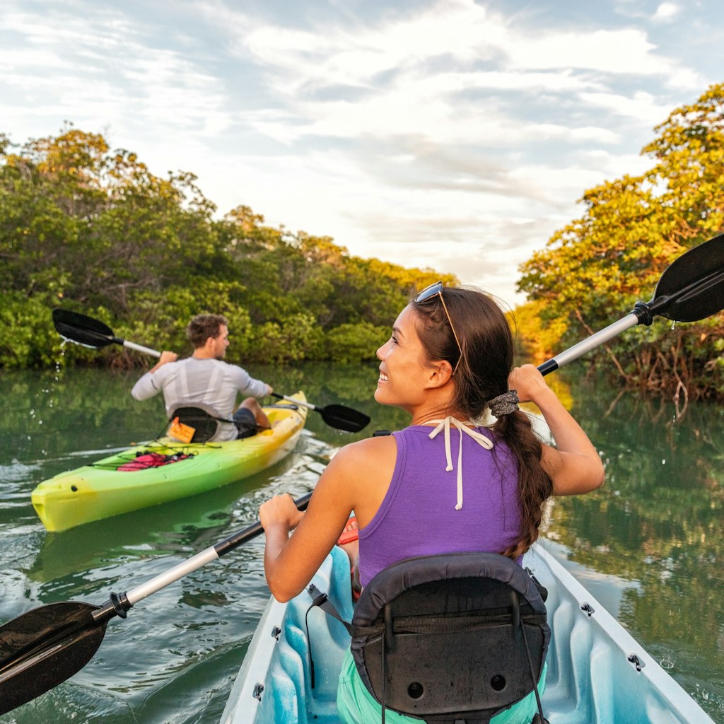Couple kayaking together in mangrove river of the Keys, Florida, USA. Tourists kayakers touring the river of Islamorada.; Shutterstock ID 1325112503; your: Ben N Buckner; gl: 65050; netsuite: Client Services; full: Florida Keys - Outdoor adventures