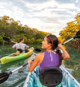 Couple kayaking together in mangrove river of the Keys, Florida, USA. Tourists kayakers touring the river of Islamorada.; Shutterstock ID 1325112503; your: Ben N Buckner; gl: 65050; netsuite: Client Services; full: Florida Keys - Outdoor adventures