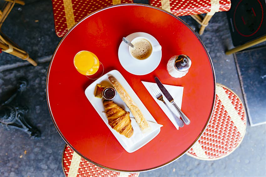 French breakfast with fresh croissants, baguettes, coffee and orange juice served in the café with high angle view