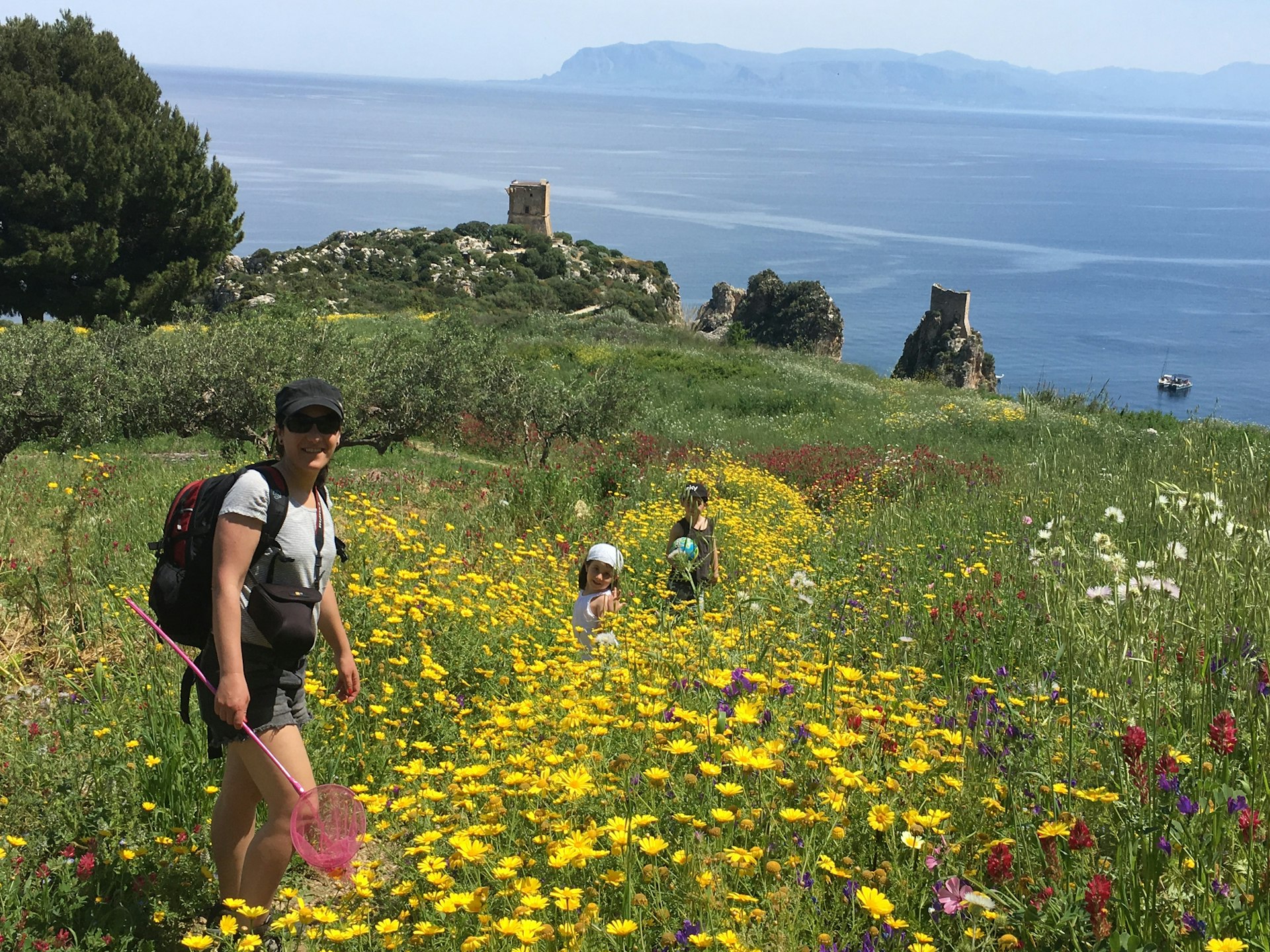 A mother and children walk among the wildflowers in the province of Trapani © Getty Images