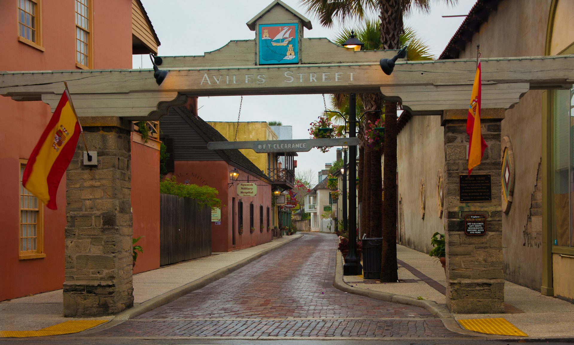 A historic street in a town with a large wooden archway welcoming you to the district