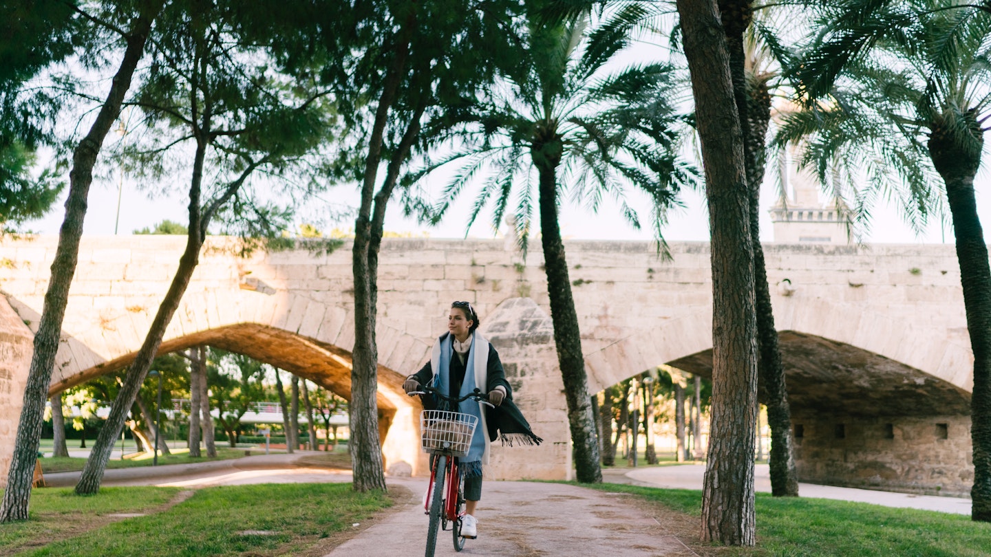 Young woman riding a bicycle in Valencia and exploring the city