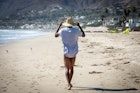Man walking along aandy beach in Malibu