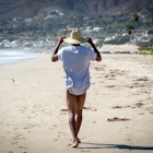 Man walking along aandy beach in Malibu