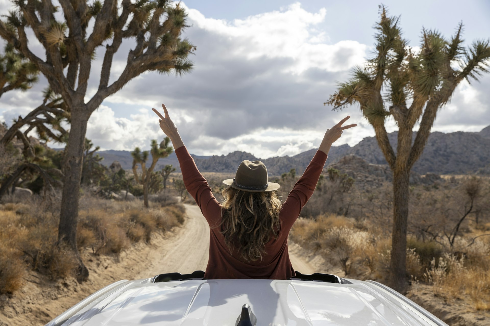 Woman standing in sunroom of car in Joshua Tree National Park