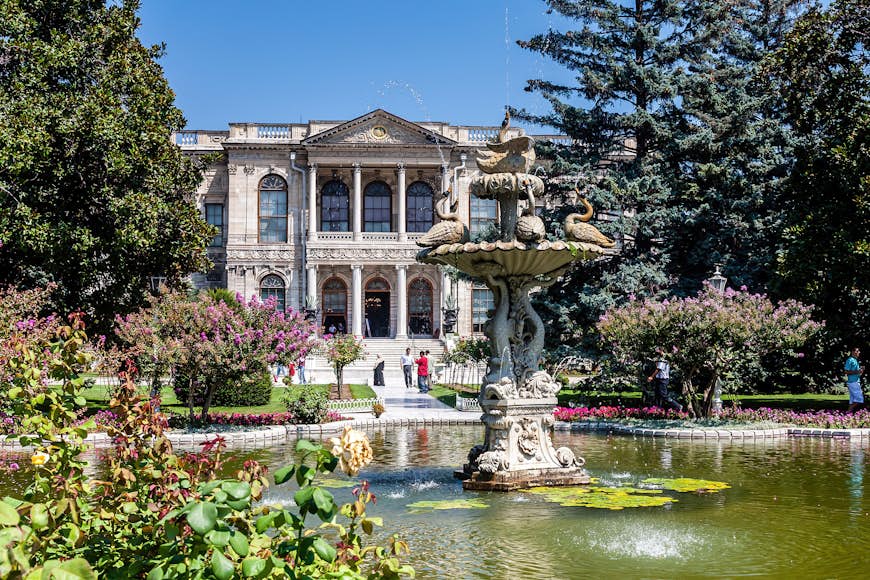 Vacker fontän och trädgårdar framför Dolmabahçe Palace i Istanbul, Turkiet