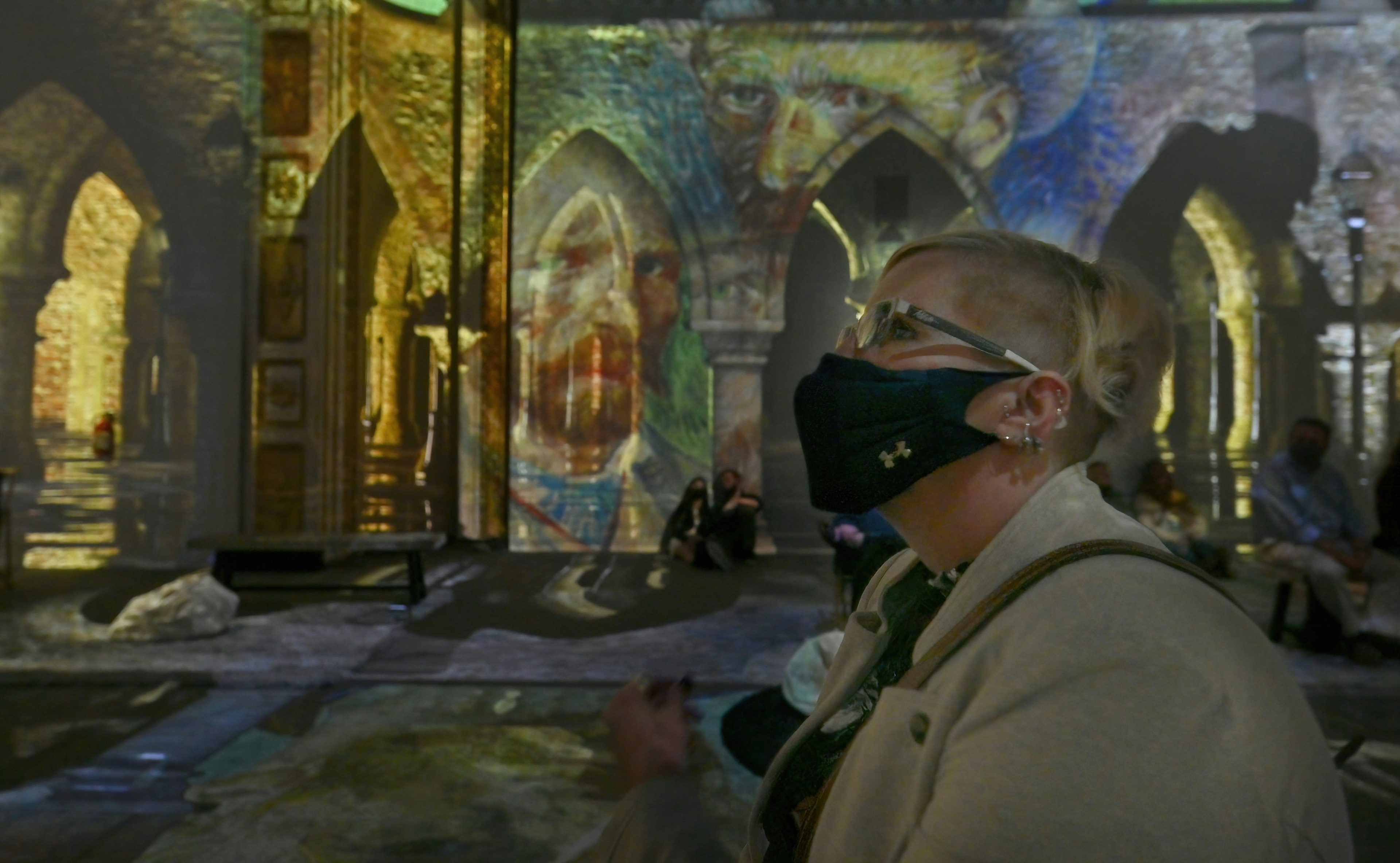 A museum-goer watches the projection-mapping at Van Gogh: The Immersive Experience