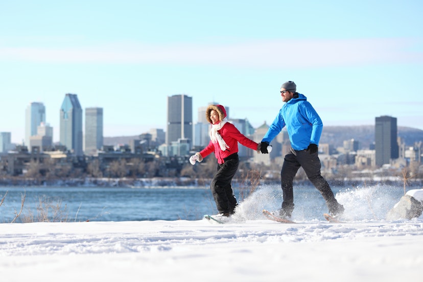 Winter couple on snowshoes in front of St Lawrence River and Montreal skyline