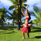 Local woman dancing amidst palm trees, Bora Bora
