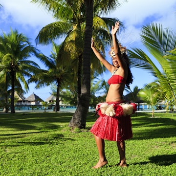 Local woman dancing amidst palm trees, Bora Bora