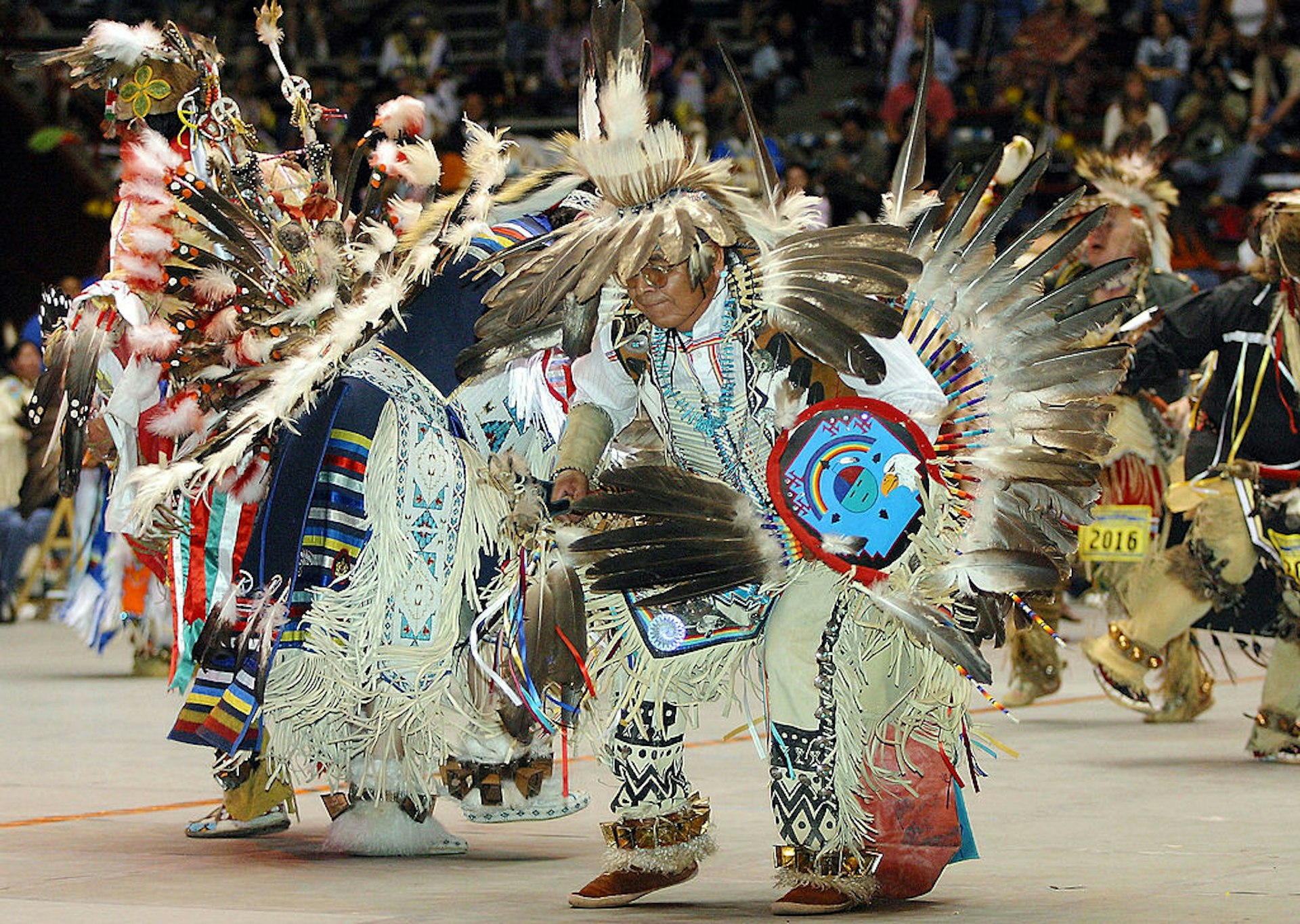 Native American dancers dressed in traditional feathered costumes