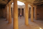 Women walking past columns of tomb in the Tomb of the Kings