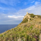 Woman on a footpath on Capo Milazzo, a promontory stretching out into the Tyrrhenian Sea. Sicily, Italy.