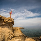 A women hiker on a rocky shoreline in the Akamas Peninsula, Cyprus