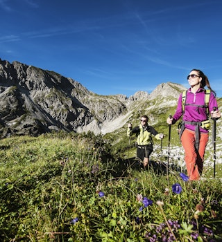 Young couple hiking at Niedere Tauer in meadow with wildflowers