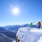 Two skiers take in the snowy views of Aspen, Colorado 