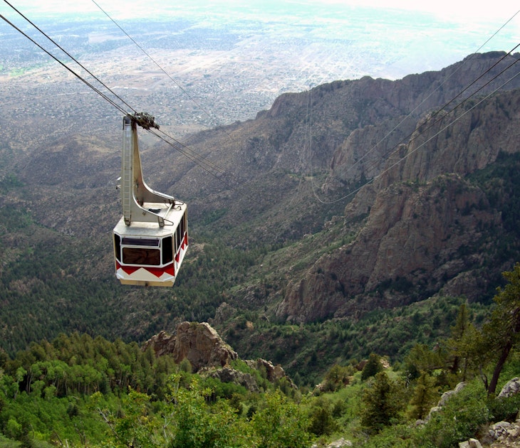 A cable car at the Sandia Peak Tramway approaching the top of Sandia Mountain, with the city of Albuquerque in the background.