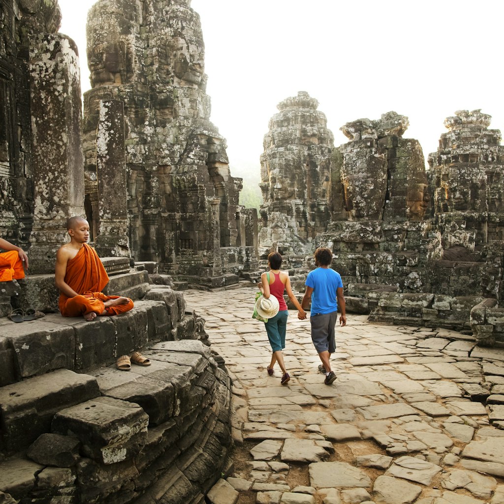 Couple visiting Buddhist temple, Angkor, Siem Reap, Cambodia