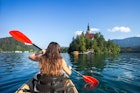 Woman kayaking toward Bled Island.