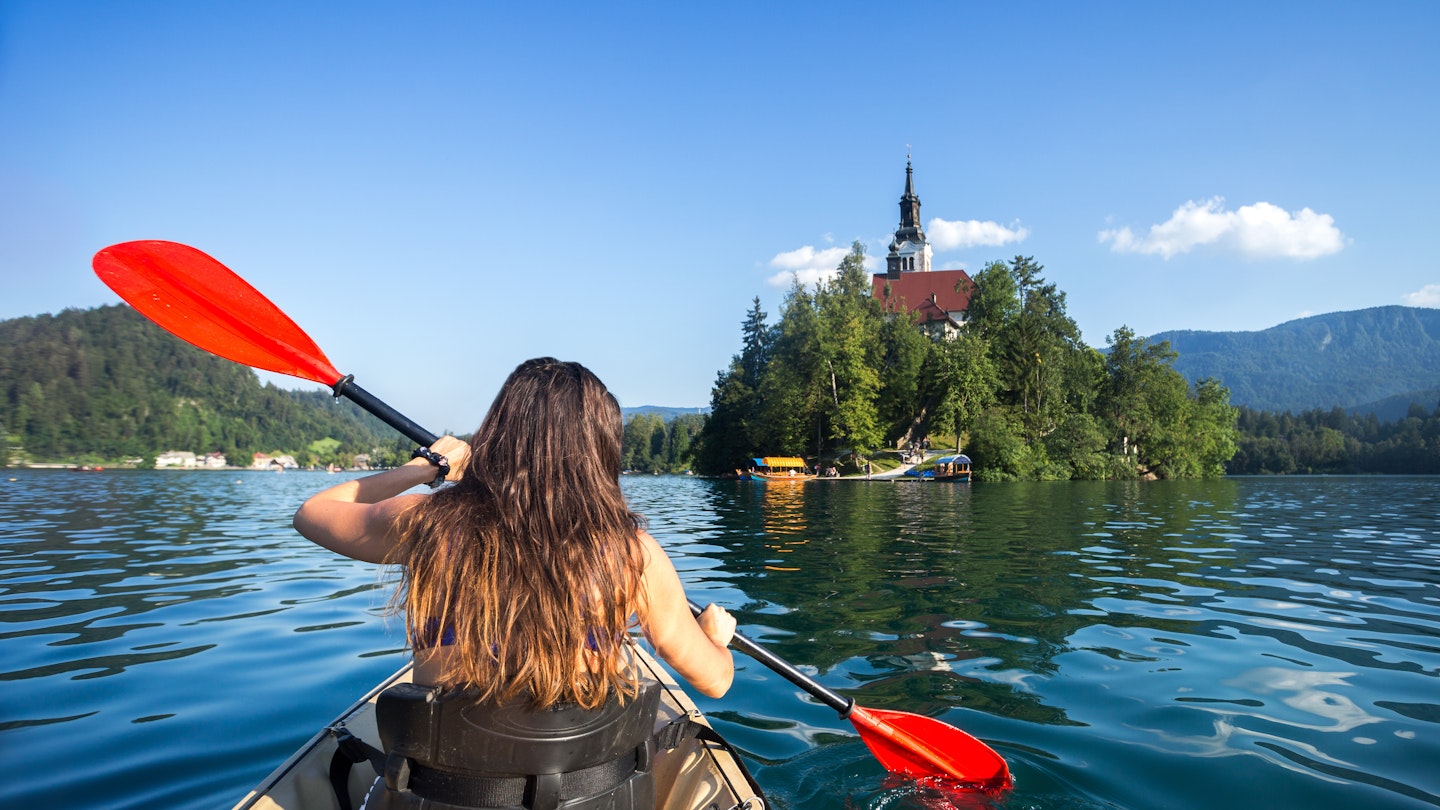 Woman kayaking toward Bled Island.