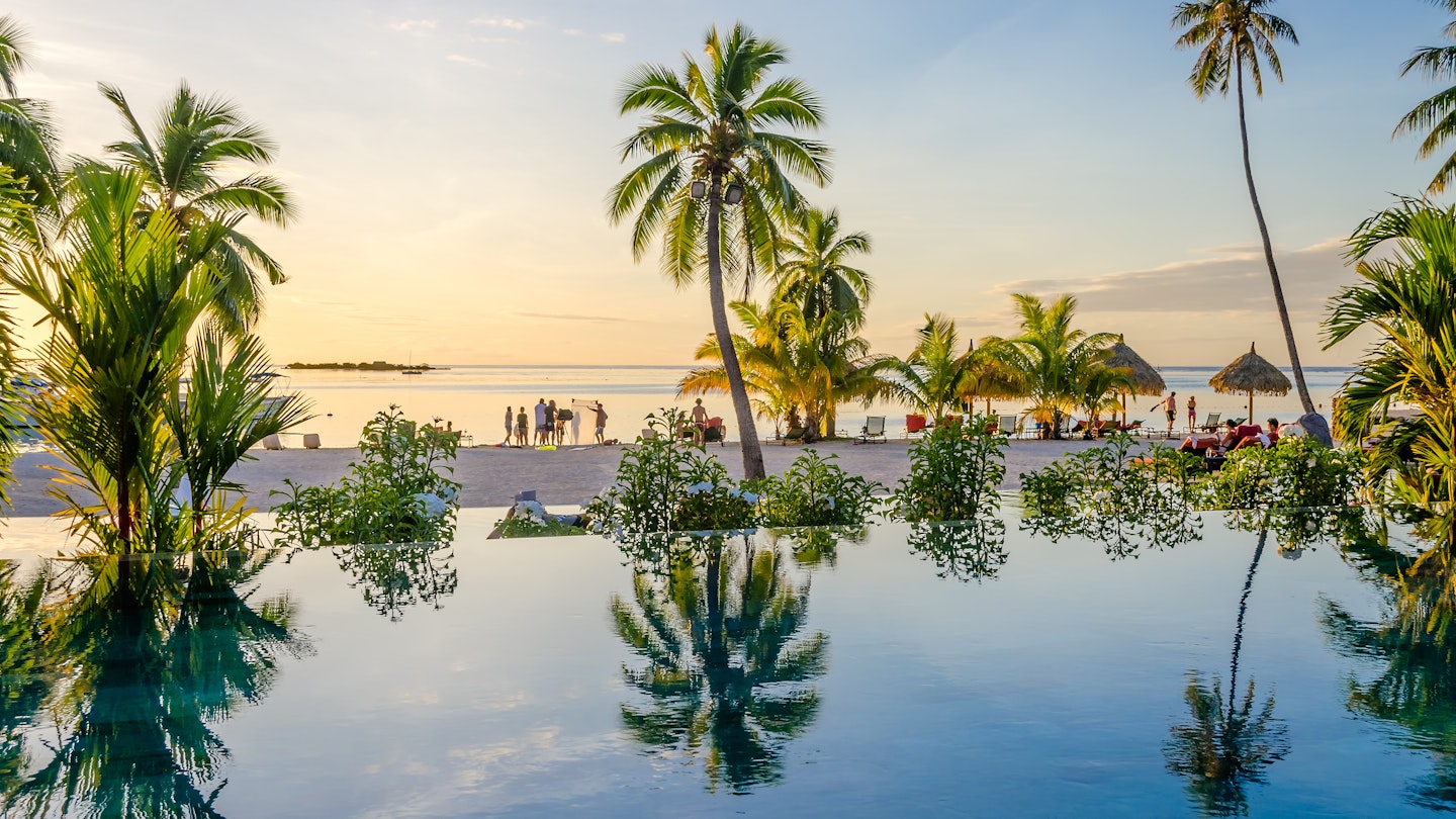 Palms reflecting over an infinity pool on the beach in Moorea, French Polynesia