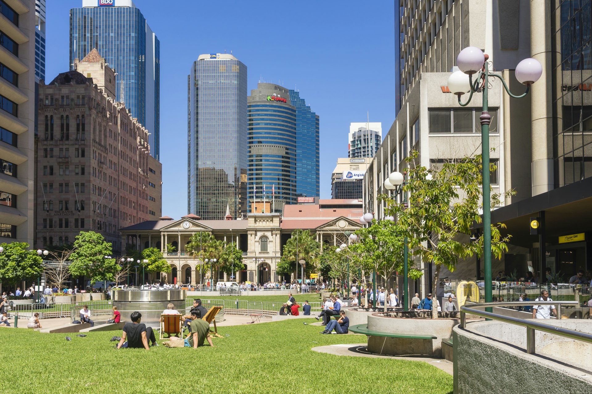 People sitting enjoying the sunshine in Post Office Square in Brisbane