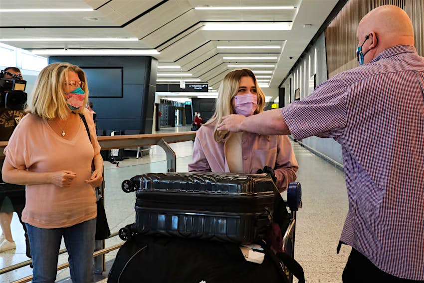 Une famille est réunie alors qu'un voyageur international traverse le hall des arrivées de l'aéroport international de Melbourne