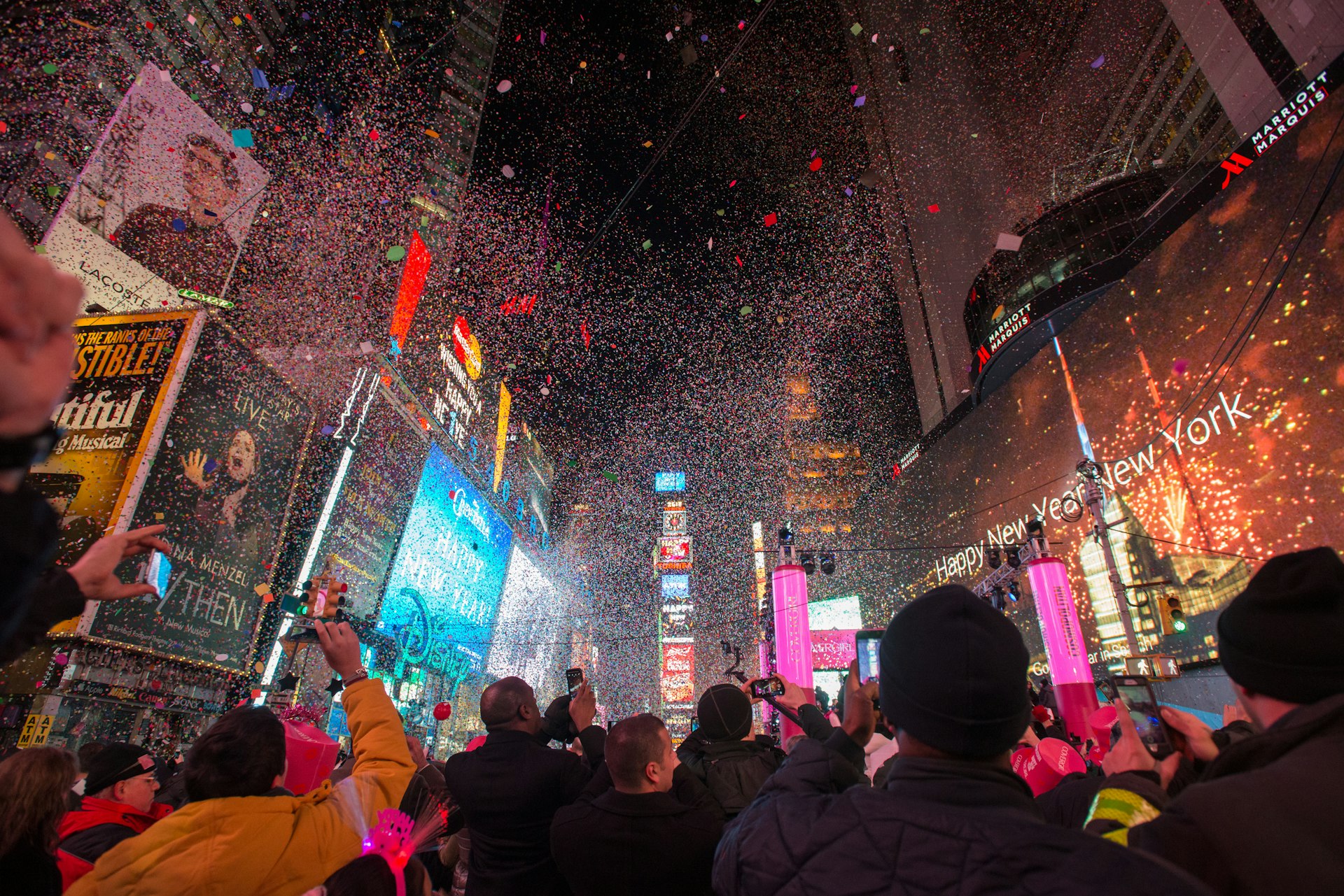 People in silhouette watching the ball drop in Times Square on New Year's Eve