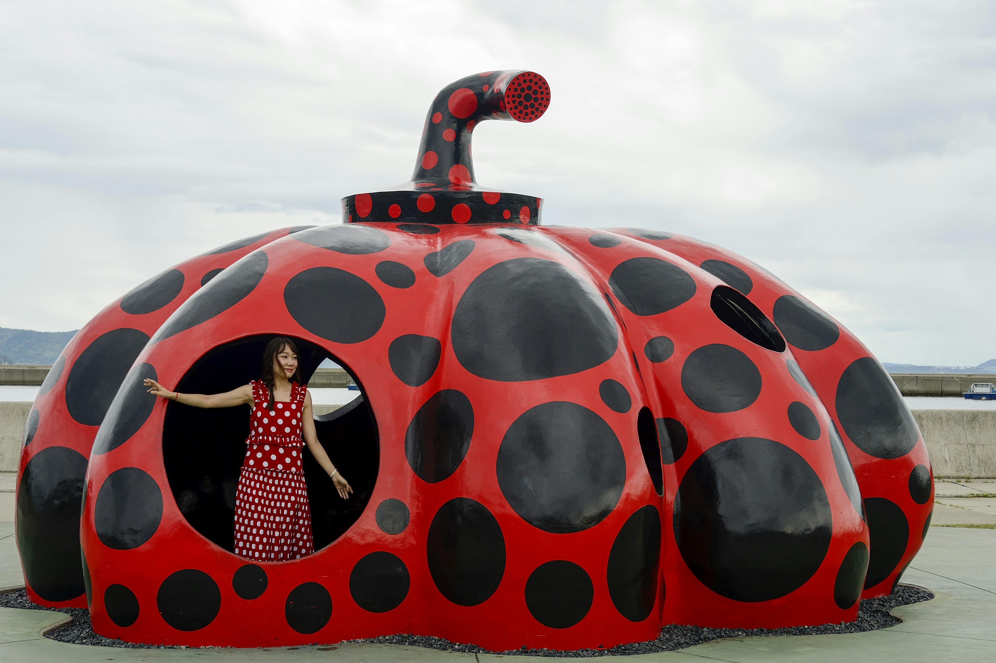 A young woman in Yayoi Kusama's Red Pumpkin on the island of Naoshima